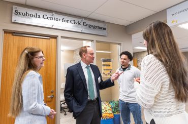 Paul Svoboda '81 (center) and President Susan Rundell Singer (left) speak with students about their experience with the new center for civic engagement. Photo by Steven Garcia '20