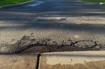 A pothole holding water along a residential road.