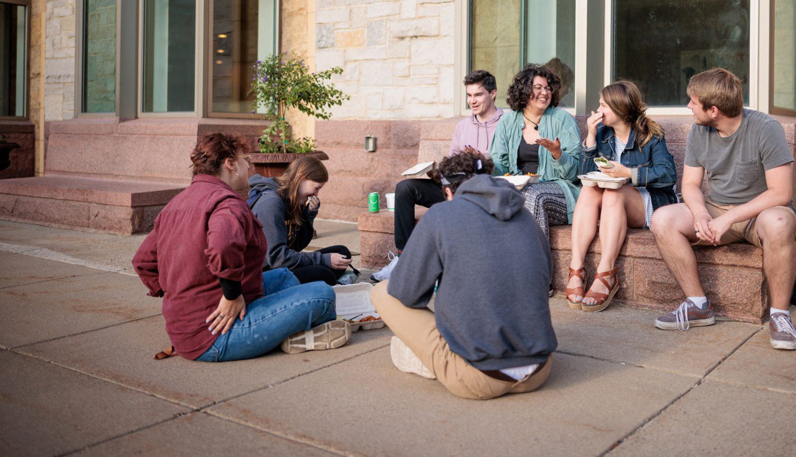 A group of St. Olaf students sit outside of Buntrock Commons