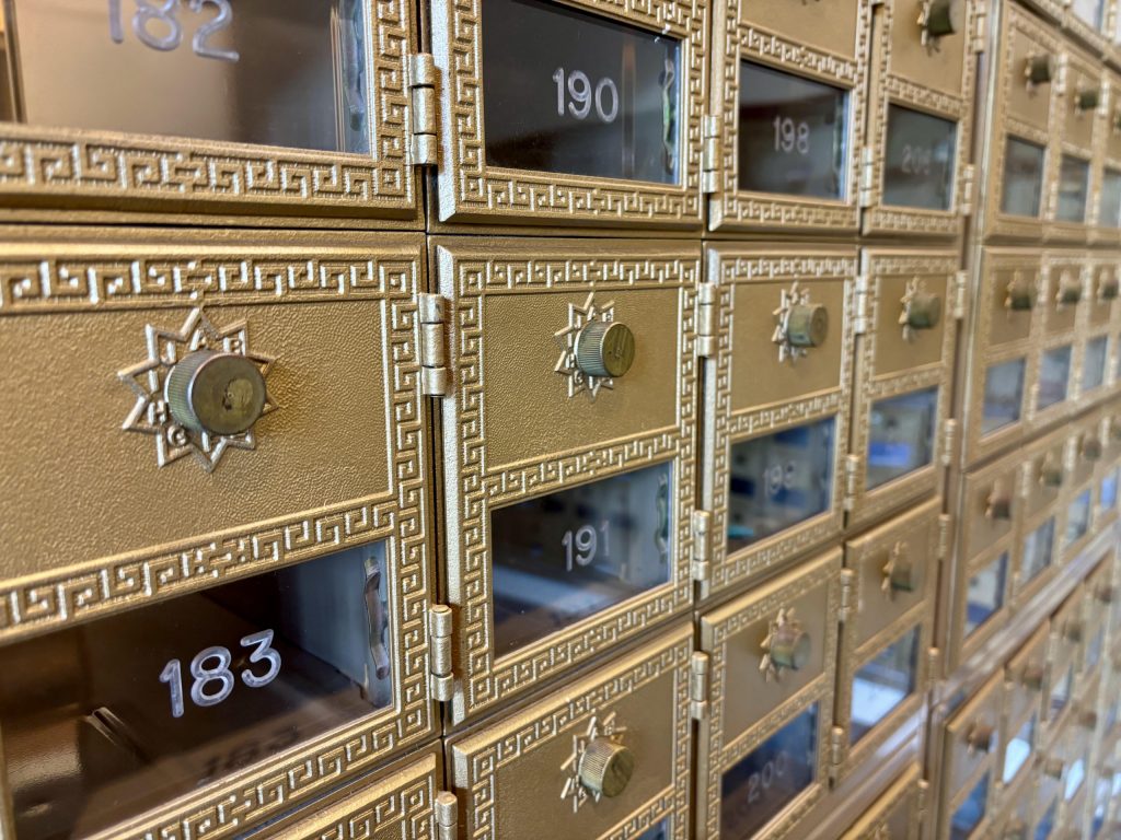 Photo of a wall of gold post office boxes taken at an angle