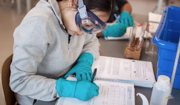 A student taking notes in the lab