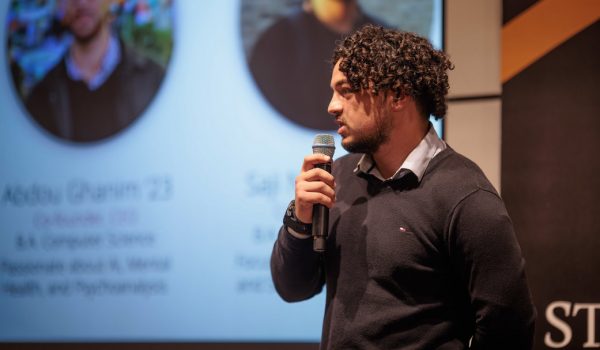 A student giving a professional presentation on stage