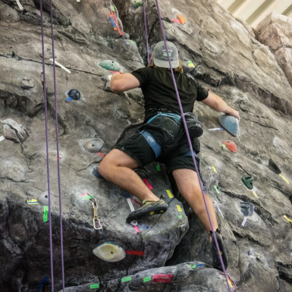 A student climbing on the rock wall